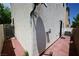 Side yard with brick pavers, stucco wall, side access door, air conditioning unit, and satellite dish at 7089 Oberling Bay Ave, Las Vegas, NV 89113