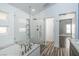 Bathroom featuring luxurious tub, walk-in shower, modern tile, and adjacent bedroom views at 8021 Yellow Daisy Ave, Las Vegas, NV 89147