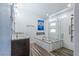 This well-lit bathroom features a soaking tub, glass-enclosed shower, and dual sinks with granite counters at 8021 Yellow Daisy Ave, Las Vegas, NV 89147