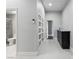 Hallway with white tile flooring and white doors, plus a granite topped sideboard at 8021 Yellow Daisy Ave, Las Vegas, NV 89147