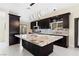 Contemporary kitchen featuring a spacious island with stone countertop, cabinetry, and modern lighting at 8021 Yellow Daisy Ave, Las Vegas, NV 89147