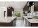 Elegant kitchen featuring stainless appliances, stone countertops, dark cabinetry and modern fixtures at 8021 Yellow Daisy Ave, Las Vegas, NV 89147