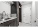The modern laundry room features granite counters, tile floors, dark wood cabinets and stainless steel sink at 8021 Yellow Daisy Ave, Las Vegas, NV 89147