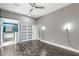 Main bedroom with gray walls, hardwood flooring, a ceiling fan, and a modern light fixture at 8021 Yellow Daisy Ave, Las Vegas, NV 89147