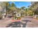 Gated community entrance with brick-paved driveway, mature trees, street lights, and manicured landscaping at 8409 Running Deer Ave # 203, Las Vegas, NV 89145