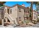 A two-story condo building with a sand-colored exterior, terracotta roof tiles, and exterior stairway at 8409 Running Deer Ave # 203, Las Vegas, NV 89145