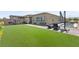 Expansive backyard with artificial turf, a pool, covered patio, and outdoor seating at 8668 Hartmont St, Las Vegas, NV 89166