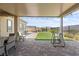 Inviting backyard with brick pavers, a covered patio, artificial turf, and meticulously maintained landscaping at 8668 Hartmont St, Las Vegas, NV 89166