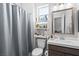 Bathroom featuring modern vanity, toilet, and shower with gray curtain at 8668 Hartmont St, Las Vegas, NV 89166