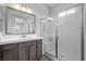 Modern bathroom with double sinks, walk-in shower and a large mirror at 8668 Hartmont St, Las Vegas, NV 89166