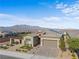 Charming single-story home with a two-car garage, desert landscaping, and a mountain backdrop at 8668 Hartmont St, Las Vegas, NV 89166