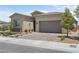 Attractive single-Gathering home featuring a two-car garage, brick accents, and desert landscaping at 8668 Hartmont St, Las Vegas, NV 89166