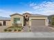 Attractive single-Gathering home featuring a two-car garage, brick accents, and desert landscaping at 8668 Hartmont St, Las Vegas, NV 89166