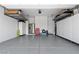 Neat garage featuring overhead storage racks and a clean, epoxy-coated floor at 8668 Hartmont St, Las Vegas, NV 89166