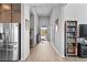 Long hallway featuring neutral tones and wood-look tile flooring, with an open view to the backyard at 8668 Hartmont St, Las Vegas, NV 89166