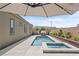 Backyard view of a modern swimming pool and spa, complete with an umbrella for shade at 8668 Hartmont St, Las Vegas, NV 89166