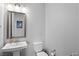 The powder room features a pedestal sink and a modern toilet at 8668 Hartmont St, Las Vegas, NV 89166