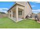 Inviting backyard featuring a covered patio, artificial grass, and BBQ area, perfect for outdoor entertaining at 9010 Wine Cellar Ave, Las Vegas, NV 89148