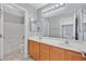 This full bathroom features double sinks and a tile-surround shower-tub combo at 9010 Wine Cellar Ave, Las Vegas, NV 89148