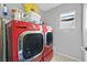 Bright laundry room featuring a modern, red LG washer and dryer set with ample storage space above at 9010 Wine Cellar Ave, Las Vegas, NV 89148