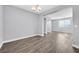 Open-concept living room with contemporary gray walls, wood-look flooring, and lots of natural light at 9010 Wine Cellar Ave, Las Vegas, NV 89148