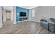 Open living space with a vibrant blue accent wall, wood-look flooring and a comfortable seating area at 9010 Wine Cellar Ave, Las Vegas, NV 89148