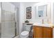 Bright bathroom featuring a glass-enclosed shower, white sink, and wooden vanity at 9112 Vista Greens Way # 204, Las Vegas, NV 89134