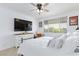 Bedroom with white walls, a large window, ceiling fan and television set above a dresser at 9112 Vista Greens Way # 204, Las Vegas, NV 89134