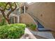 Charming two-story condo featuring stucco facade, stairs to front door, white columns, and mature landscaping at 9112 Vista Greens Way # 204, Las Vegas, NV 89134