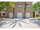 Modern townhome featuring three individual garages, awnings over the windows, and mature palm trees at 9112 Vista Greens Way # 204, Las Vegas, NV 89134