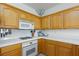 This kitchen features light wood cabinetry and white countertops and backsplash at 9112 Vista Greens Way # 204, Las Vegas, NV 89134