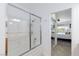 Clean bathroom with a tiled shower featuring a glass door, chrome fixtures, and a view to the bedroom at 9112 Vista Greens Way # 204, Las Vegas, NV 89134
