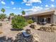 Landscaped backyard boasts colorful foliage and rock accents leading to the home's charming patio at 10417 Sea Palms Ave, Las Vegas, NV 89134