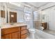 Well-lit bathroom has vanity with cabinets and drawers, toilet, and bathtub with sliding door at 10417 Sea Palms Ave, Las Vegas, NV 89134