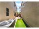 Exterior shot of fenced backyard featuring a strip of grass and stone pavers at 10917 Mount Pendleton St, Las Vegas, NV 89179