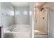 Bathroom featuring a soaking tub with tile surround and a separate glass enclosed shower at 10917 Mount Pendleton St, Las Vegas, NV 89179