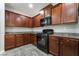 Kitchen with dark wood cabinets, gray counters, and black appliances at 10917 Mount Pendleton St, Las Vegas, NV 89179