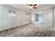 Spacious living room featuring plush carpeting, abundant natural light, and a ceiling fan at 10917 Mount Pendleton St, Las Vegas, NV 89179