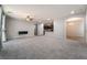 Large living space featuring modern gray carpet that flows into the kitchen and dining areas at 10917 Mount Pendleton St, Las Vegas, NV 89179