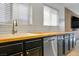 Modern kitchen featuring black cabinets, stainless appliances, and a butcher block countertop at 11091 Parete Ct, Las Vegas, NV 89141