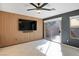 Stylish living room features tile flooring, wood slat wall, flat screen TV, and sliding glass doors at 11091 Parete Ct, Las Vegas, NV 89141