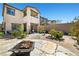 Landscaped backyard featuring a patio area, a fire pit, and a well-maintained lawn, perfect for outdoor gatherings at 11652 Desert Hollow Ave, Las Vegas, NV 89138