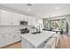 Bright kitchen with white cabinets, stainless steel appliances and a center island, opening to the patio at 11652 Desert Hollow Ave, Las Vegas, NV 89138