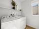 Bright laundry room includes washer, dryer, and storage shelving at 11652 Desert Hollow Ave, Las Vegas, NV 89138