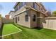 Backyard with green turf grass, and a tan fence and house at 11953 Haven St, Las Vegas, NV 89183