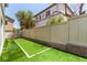 Backyard showing fenced yard with faux grass and the rear of the home at 11953 Haven St, Las Vegas, NV 89183