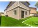 Backyard area features well-maintained faux grass and stucco house with sliding glass door at 11953 Haven St, Las Vegas, NV 89183