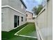 A low-maintenance backyard with artificial turf bordered by a white fence and access to the house at 11953 Haven St, Las Vegas, NV 89183