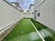 Artificial turf lines the small backyard, enclosed by a white fence, and features a putting green at 11953 Haven St, Las Vegas, NV 89183