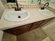 Bathroom vanity featuring double sinks, tile countertops, and dark wood cabinets at 11953 Haven St, Las Vegas, NV 89183